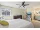 Bright bedroom with a ceiling fan, dresser, TV, and ensuite bathroom, well-lit by a window at 43 Dominion Dr, Zionsville, IN 46077