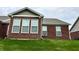 Rear exterior of a brick single Gathering home with green grass and some mature trees at 4327 Switchgrass Way, Indianapolis, IN 46237