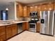 Modern kitchen featuring stainless steel appliances, light countertops, and warm wood cabinets, perfect for cooking at 4327 Switchgrass Way, Indianapolis, IN 46237
