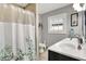 Modern bathroom with double sinks, a shower with a floral curtain, and a window at 433 Eastern Ave, Indianapolis, IN 46201