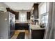 An open kitchen features stainless steel appliances, dark cabinetry, and wood flooring at 433 Eastern Ave, Indianapolis, IN 46201