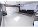 Spacious and spotless garage with epoxy floors, tv, couches, and basketball hoop at 4421 Greenmeadow Ct, Indianapolis, IN 46235
