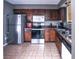 Well-equipped kitchen with stainless steel appliances, dark wood cabinets, and tiled floors, perfect for culinary enthusiasts at 4421 Greenmeadow Ct, Indianapolis, IN 46235