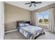 Cozy bedroom with a ceiling fan, plush carpeting, and a bright window overlooking the landscape at 4634 E 1000 N, Pittsboro, IN 46167