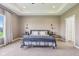 Elegant primary bedroom boasts a tray ceiling, two sconces, and a large window with natural light at 4634 E 1000 N, Pittsboro, IN 46167