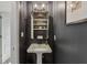 Stylish powder room with black walls, shelving, and a pedestal sink at 4634 E 1000 N, Pittsboro, IN 46167