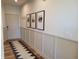 Inviting hallway showcasing wainscoting detail, elegant art, and a patterned runner on hardwood floors at 4810 Oak Hl Dr, Lebanon, IN 46052