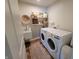 Cozy laundry room with modern washer and dryer, a charming sink, and rustic shelving at 4810 Oak Hl Dr, Lebanon, IN 46052