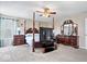 Bedroom with neutral colors and a four poster bed, dresser, and a ceiling fan at 4922 Birmingham Dr, Indianapolis, IN 46235