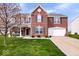 Charming two-story brick home with a well-manicured lawn and attached two-car garage at 4922 Birmingham Dr, Indianapolis, IN 46235
