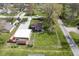An aerial perspective of a house with a garage, gravel driveway, and well-manicured lawn, offering a serene setting at 502 N Maple St, Ingalls, IN 46048