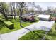 Aerial showcases home with a garage and gravel driveway, surrounded by greenery, creating a tranquil residential setting at 502 N Maple St, Ingalls, IN 46048