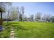 This backyard features a large grassy area with trees and a detached garage at 502 N Maple St, Ingalls, IN 46048