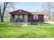 Inviting single-Gathering home features a well-manicured lawn, front porch, and detached garage at 502 N Maple St, Ingalls, IN 46048