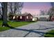 Charming red home features a gravel driveway leading to a detached garage at 502 N Maple St, Ingalls, IN 46048