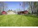 A charming red house with a spacious green lawn and American flag is perfect for outdoor enjoyment at 502 N Maple St, Ingalls, IN 46048