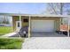 Detached garage with a roll up door, side door and covered carport area at 502 N Maple St, Ingalls, IN 46048
