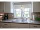 Bright kitchen sink area features a designer faucet and window overlooking the yard at 502 N Maple St, Ingalls, IN 46048