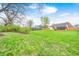 Spacious backyard with green lawn, mature trees, and a wooden fence, offering ample space for activities at 5126 Shadow Pointe Dr, Indianapolis, IN 46254