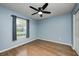 Bright bedroom featuring sleek hardwood floors, a ceiling fan, and natural light from a large window at 5126 Shadow Pointe Dr, Indianapolis, IN 46254