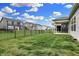 A long backyard view showcasing an open green lawn, covered patio and black metal fencing at 5309 Spyglass Dr, Whitestown, IN 46075