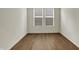 A bright empty room featuring wood flooring and windows that bring in natural light at 5309 Spyglass Dr, Whitestown, IN 46075