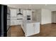 Elegant kitchen with white cabinets, stainless steel appliances, island, and hardwood flooring at 5309 Spyglass Dr, Whitestown, IN 46075