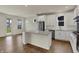 Modern kitchen with white cabinetry, stainless steel appliances, a center island, and hardwood floors at 5309 Spyglass Dr, Whitestown, IN 46075