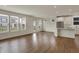 Open-concept living room with hardwood floors, bright windows, and a modern kitchen in the background at 5309 Spyglass Dr, Whitestown, IN 46075