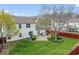 A well maintained backyard, with green grass, manicured shrubbery and red wooden fence at 5817 Thompson Park Blvd, Indianapolis, IN 46237