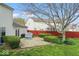 A well maintained backyard with a brick patio, green grass, manicured shrubbery and red wooden fence at 5817 Thompson Park Blvd, Indianapolis, IN 46237
