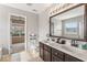 Well-lit bathroom features a double vanity, ceramic tile floor and a large framed mirror at 5817 Thompson Park Blvd, Indianapolis, IN 46237