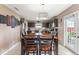 Dining room with a large wooden table, modern chandelier, and access to the kitchen at 5817 Thompson Park Blvd, Indianapolis, IN 46237