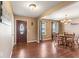 Charming dining area featuring hardwood floors, elegant lighting, and a welcoming front door at 5817 Thompson Park Blvd, Indianapolis, IN 46237