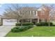 Charming two-story brick home featuring a well-manicured lawn and attached two-car garage at 5817 Thompson Park Blvd, Indianapolis, IN 46237