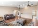 Spacious living room featuring hardwood floors, ceiling fans, and a comfortable leather sofa, perfect for relaxing at 5817 Thompson Park Blvd, Indianapolis, IN 46237
