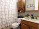 Bathroom with wood cabinets, patterned shower curtain, white toilet, and gray walls at 59 N Ridgeview Dr, Indianapolis, IN 46219