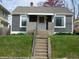 Front view of a gray home featuring a brick porch with a set of concrete steps at 59 N Ridgeview Dr, Indianapolis, IN 46219