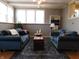 Living room features 2 blue couches, a dark wood coffee table, and neutral walls at 59 N Ridgeview Dr, Indianapolis, IN 46219