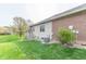 Lush backyard with a brick exterior, wooden stairs, and vibrant green grass at 6081 Boulder Ct, Columbus, IN 47201