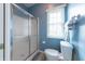 Well-lit bathroom features frosted glass shower door, toilet, and towel rack under a window at 6081 Boulder Ct, Columbus, IN 47201