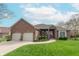 Charming brick home featuring a well-manicured lawn, a two-car garage, and beautiful landscaping at 6081 Boulder Ct, Columbus, IN 47201