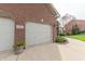 Brick home featuring a white garage door, driveway, and manicured landscaping at 6081 Boulder Ct, Columbus, IN 47201