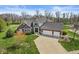 Aerial view of a brick home with an attached three car garage and a large concrete driveway at 621 Foxboro Dr, Avon, IN 46123