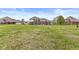 Spacious backyard with manicured lawn showcasing the beautiful brick house at 621 Foxboro Dr, Avon, IN 46123