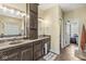 Bathroom featuring double sinks, stylish wood cabinets and hardware, with access to the closet at 621 Foxboro Dr, Avon, IN 46123