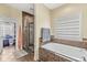 Bright bathroom with a soaking tub under a window and a glass enclosed shower with tile surround at 621 Foxboro Dr, Avon, IN 46123