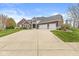 Charming brick home featuring an attached three car garage and a long concrete driveway at 621 Foxboro Dr, Avon, IN 46123