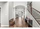 Home's foyer area showcasing hardwood floors, staircase, and an arched entryway to the living area at 621 Foxboro Dr, Avon, IN 46123