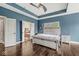 Spacious primary bedroom with blue walls, a tray ceiling, wood floors, and an ensuite bathroom at 621 Foxboro Dr, Avon, IN 46123